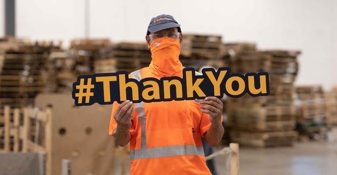 48forty employee holding Thank You sign in warehouse